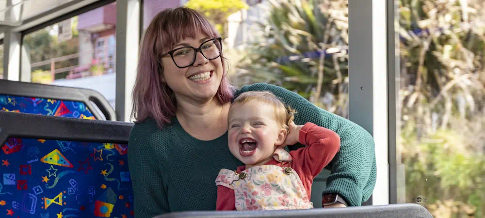 Smiling woman and laughing toddler on bus